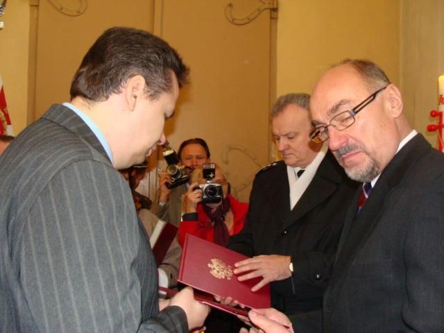 Посол Польши в Литве Я.Сколимовски вручает Ж.Радавичюсу документ о присвоении очередного воинского звания его погибшему родственнику
