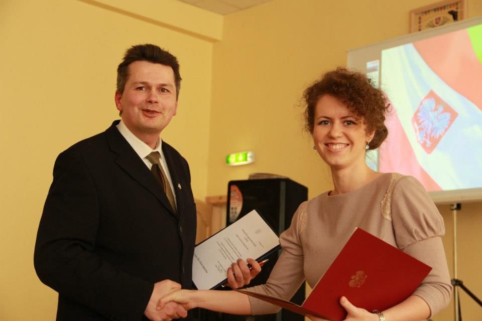 Эльжбета Кузборска награждает Жильвинаса Радавичюса благодарственным письмом.