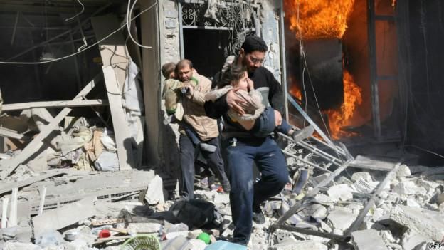 Жители Алеппо выбегают из горящего здания, куда попали, как предполагается, баррельные бомбы