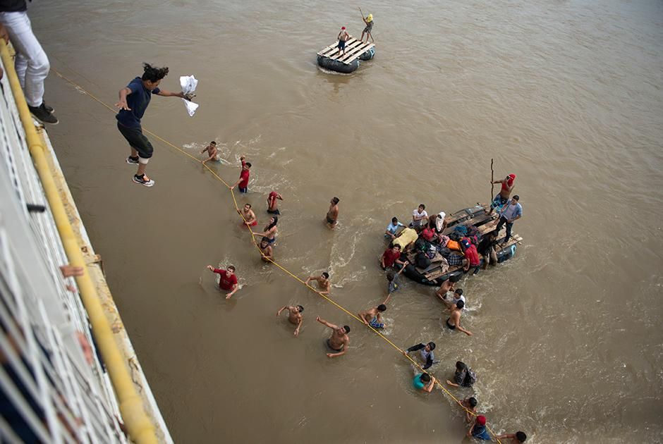 Уставшие от ожидания на гватемальско-мексиканской границе мигранты прыгают в воды реки Сучьяте Фото: Oliver de Ros / AP