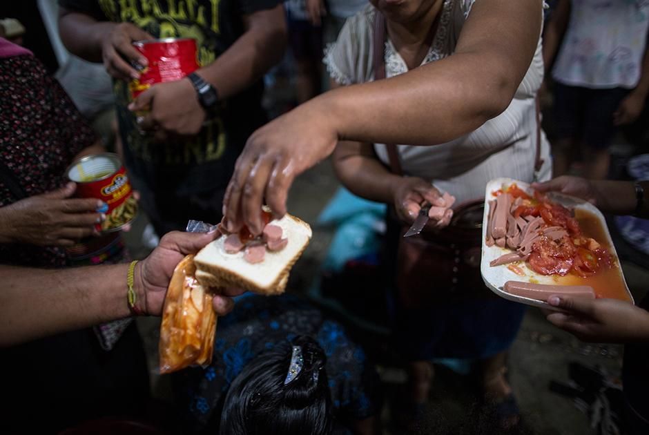 Мигранты едят пожертвованную им еду Фото: Rodrigo Abd / AP