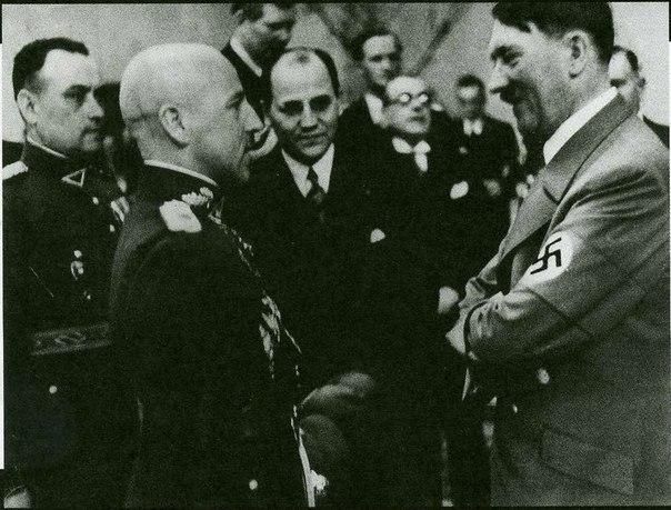 Посол Литвы в Германии, будущий глава Фронта литовских активистов полковник Казис Шкирпа (на втором плане в центре) и Адольф Гитлер. Апрель 1939 г.