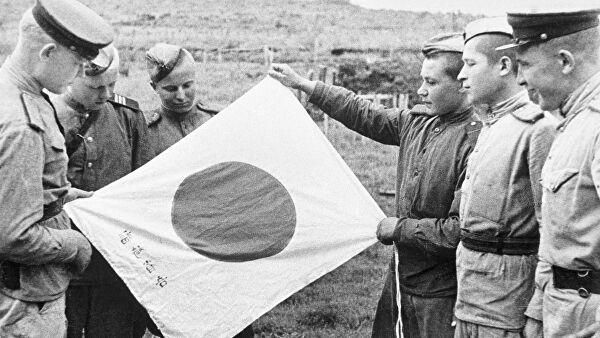 Советские воины рассматривают брошенный при отступлении японский флаг. Архивное фото. © РИА Новости