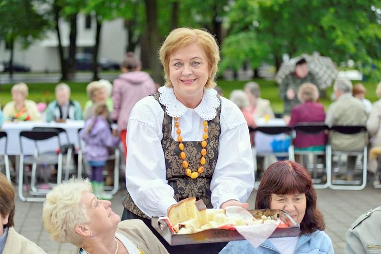 На празднике города мэр Н.Диргинчене угощает гостей пирогом своего приготовления
