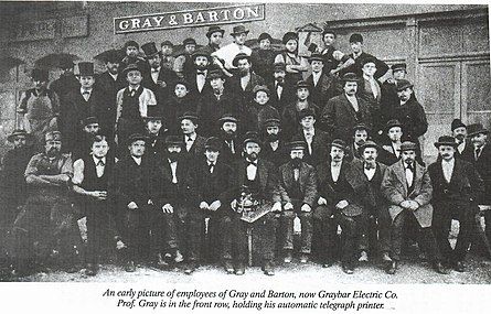 Сотрудники компании "Gray & Barton". Элиша Грей сидит в центре и держит в руках печатающий телеграф собственного изобретения.
