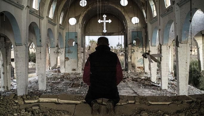 Валерий Мельников/РИА «Новости» Житель одной из деревень в провинции Эль-Хасаке на северо-востоке Сирии молится в храме Святого Георгия, уничтоженного боевиками ИГ