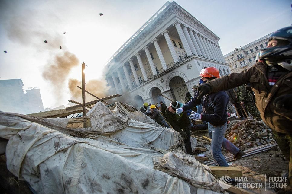 Сторонники оппозиции кидают камни на площади Независимости в Киеве. 19 февраля 2014 © РИА Новости / Андрей Стенин