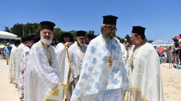 EPA Image caption Священники греческой православной церкви в Австралии отмечают праздник Богоявления (Теофании) у залива Ярра 7 января 2018 года