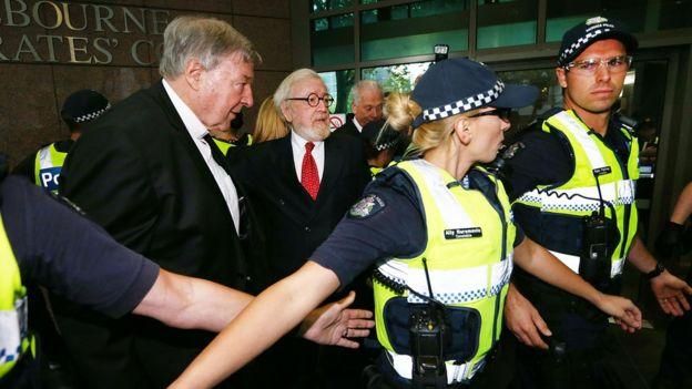 GETTY IMAGES Image caption Кардинала и его адвоката в суд эскортировала полиция