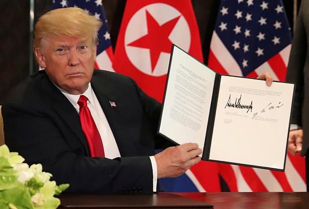 Трамп показывает подписанный документ Фото: Jonathan Ernst / Reuters