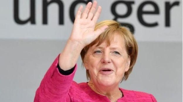 AFP Image caption Ангела Меркель хотела бы поехать на футбол, однако сейчас для этого неподходящий политический момент