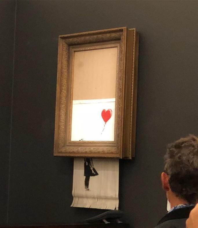 BANKSY'S GIRL WITH RED BALLOON MYSTERIOUSLY SHREDS FOLLOWING ITS SALE AT SOTHEBY'S LONDON.