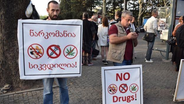 Участники контракции протестуют против проведения фестиваля. На плакате написано "Наркомания - это смерть!"