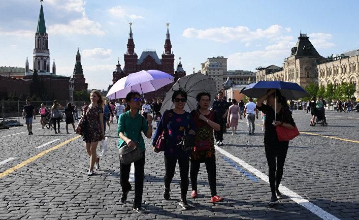 Туристы гуляют на Красной площади в Москве