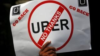 REUTERS Image caption Против Uber протестуют таксисты многих стран. На фото - плакат в руках у протестующего в индийском Мумбаи