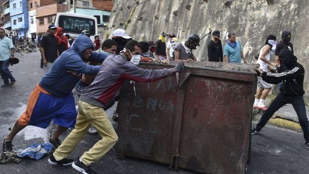 AFP Image caption Участники уличных протестов требуют отставки президента Николаса Мадуро