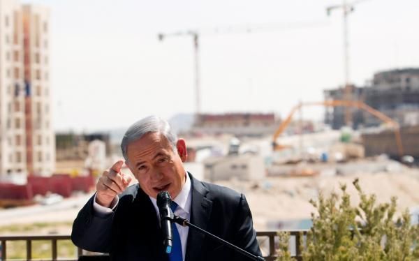 Израильский премьер Биньямин Нетаньяху на фоне очередного израильского поселения на Западном берегу. 2015 г. REUTERS/Ronen Zvulun/File Photo