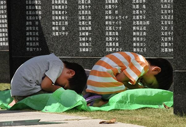 © AFP 2019 / Toru Yamanaka Дети во время молитвы у памятника погибшим в Битве за Окинаву