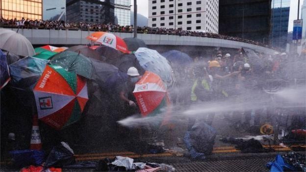 REUTERS Image caption Протестующие пытались защититься с помощью зонтиков - памятного символа протестов 2014 года