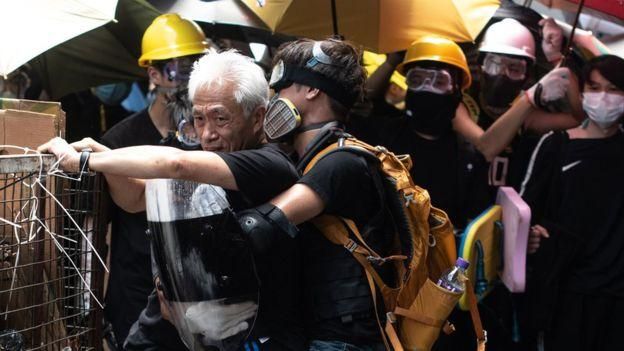PHILIP FONG/AFP/GETTY IMAGES Image caption Протестующие держат депутата от оппозиции, который призывал их к порядку