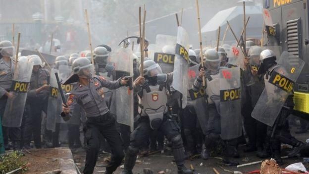 REUTERS Image caption Полицейских закидали камнями, они ответили слезоточивым газом
