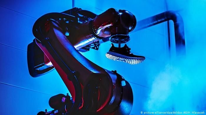 Промышленный робот на заводе Adidas Speedfactory в Ансбахе с готовой кроссовкой