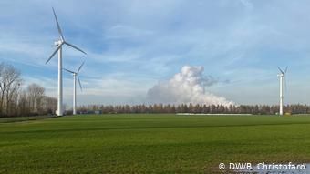Ветрогенераторы и дым от угольной электростанции в Лангервее