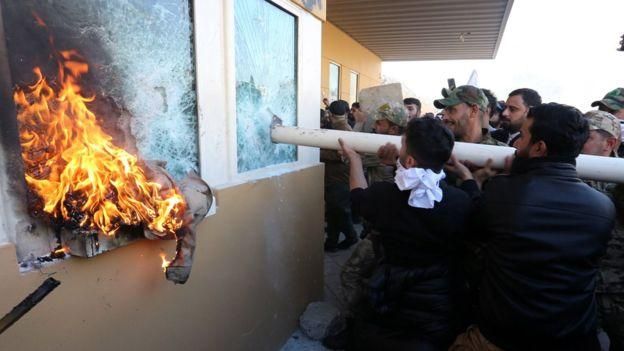 EPA Image caption Во вторник протестующие подожгли КПП посольства и ворвались внутрь