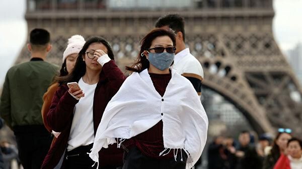 © REUTERS / Gonzalo Fuentes Женщина в медицинской маске в Париже