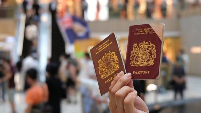 REUTERS Image caption Демонстрант в Гонконге показывает свой британский заморский паспорт