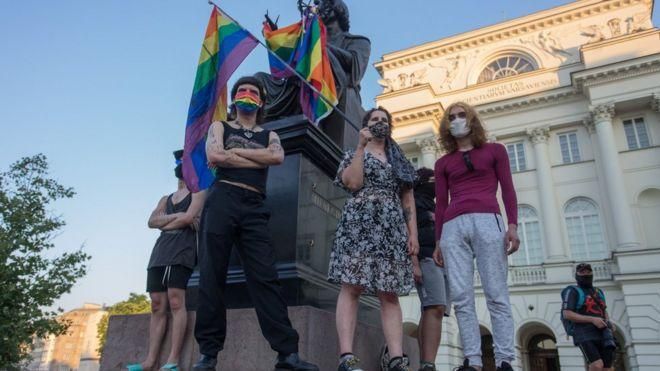 REUTERS Image caption За оборачивание памятника в радужный флаг в Польше можно получить тюремный срок