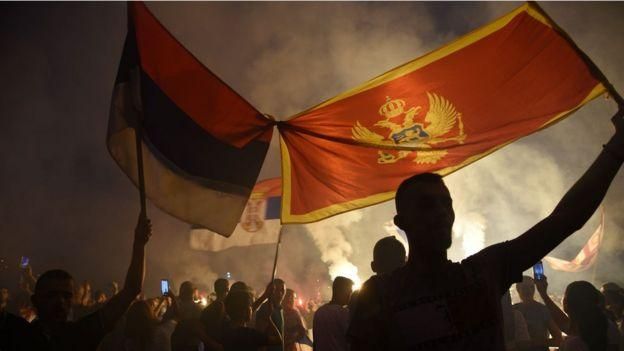 EPA Image caption Победу оппозиции толпы праздновали на улицах. Некоторые - под символично связанными флагами Сербии и Черногории