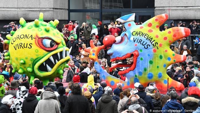 Фигура коронавируса встречает фигуру "карнавального вируса" в Дюссельдорфе в феврале 2020 года