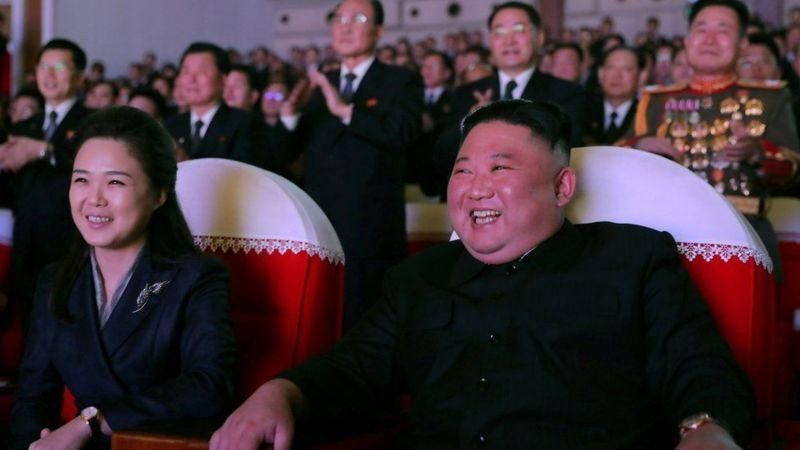 REUTERS Подпись к фото, Ким Чен Ын и его супруга с улыбкой смотрели праздничный концерт