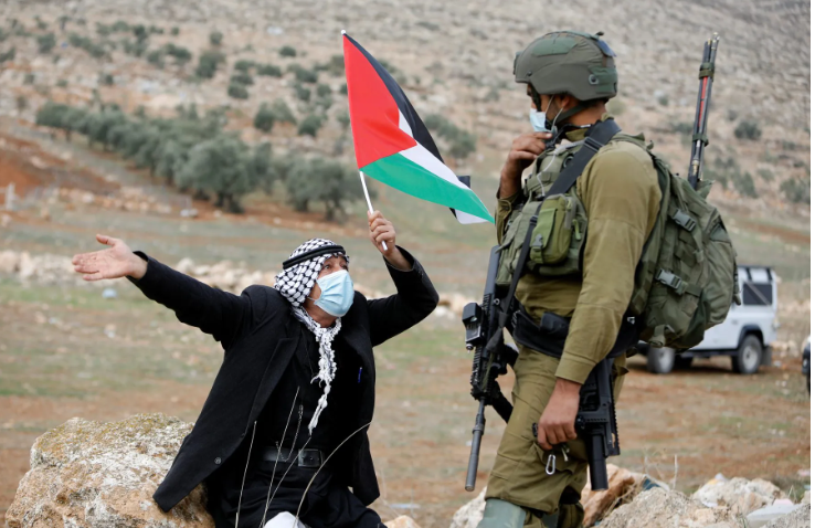Палестинский демонстрант перед израильским солдатом во время акции протеста против еврейских поселений в Бейт-Даджане на оккупированном Израилем Западном берегу. 20 ноября 2020 года. Фото: Raneen Sawafta / Reuters / Forum
