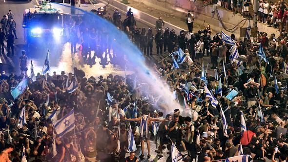AFP Подпись к фото, Полиция применяет против протестующих водометы и грубую физическую силу