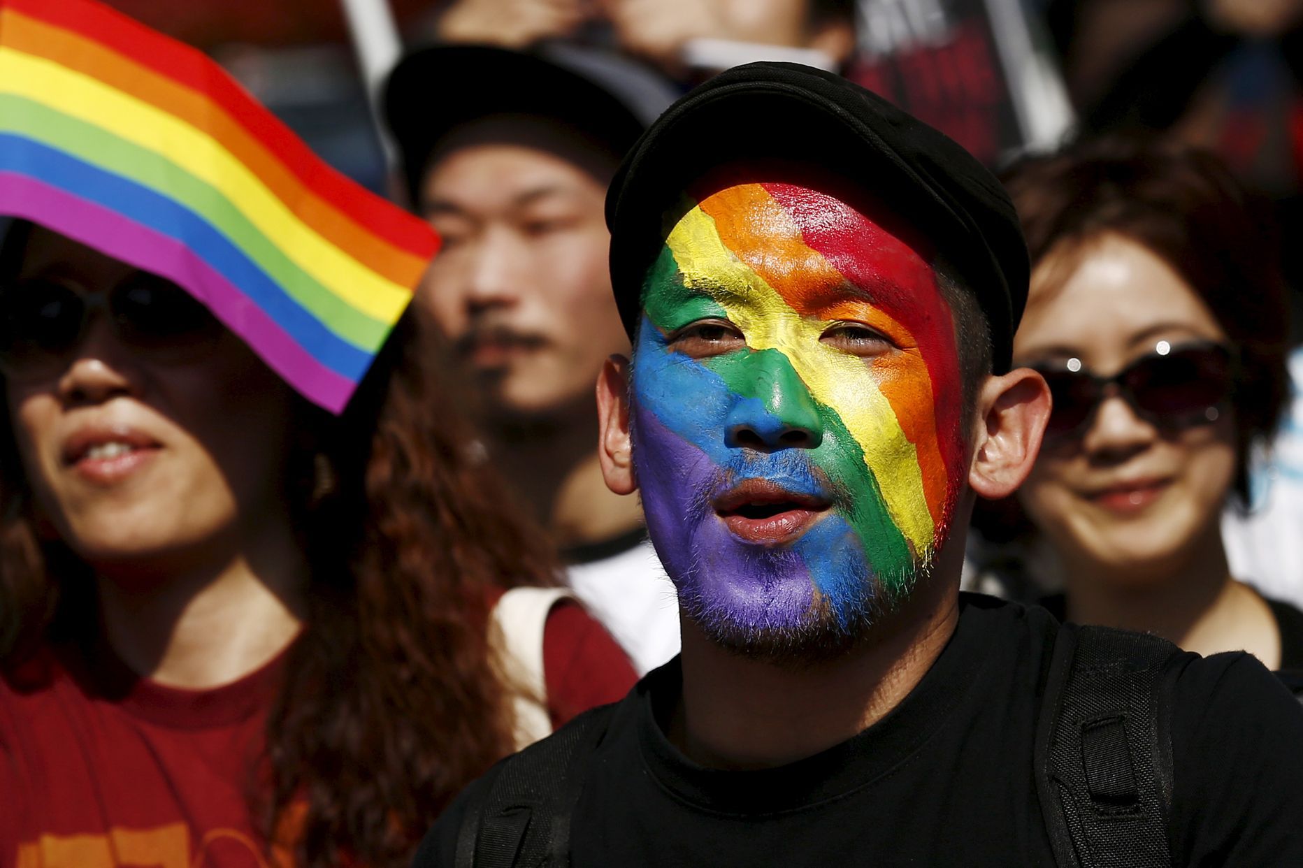 Мужчина, чье лицо раскрашено в цвета радуги, принимает участие в параде Tokyo Rainbow Pride в Токио. Фото: Thomas Peter